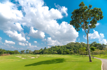 The beautiful view green grass , sand bunker at  golf course with blue white cloud sky background