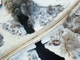 Aerial view of forest and river covered with snow , bird's eye view