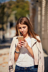 Young attractive woman using cellphone in the urban surronders.