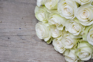 White roses on wooden background