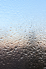 The frozen drops on the patterned frosty winter window