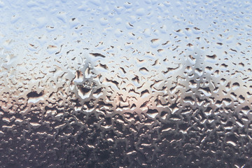 The frozen drops on the patterned frosty winter window