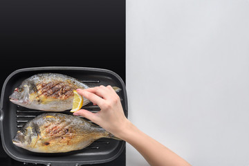 cropped shot of person squeezing lemon while frying fish