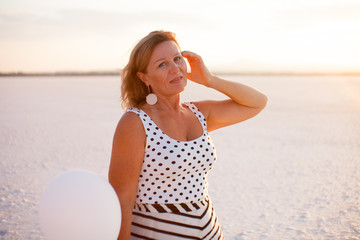 Fototapeta na wymiar Portrait of pretty woman with baloons on salt lake in Larnaca, Cyprus