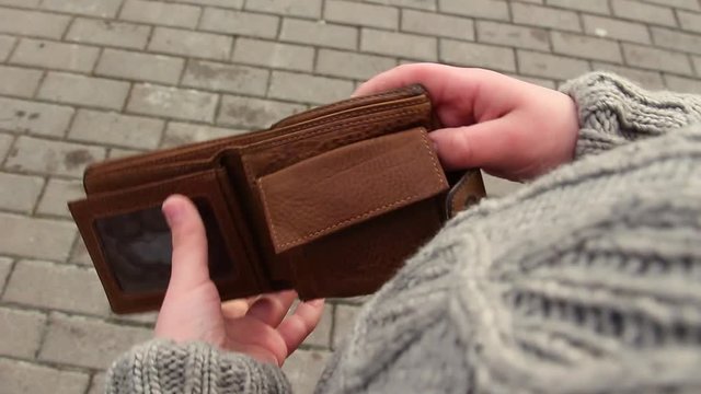Stealing money from male leather wallet outdoors concept. Real time full hd video footage.