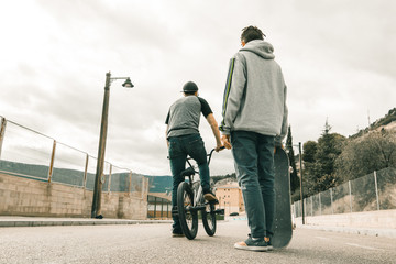 Extreme urban sports concept .Young people with bmx bicycles and skateboards on the street