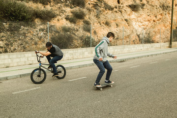 Extreme urban sports concept .Young people with bmx bicycles and skateboards on the street