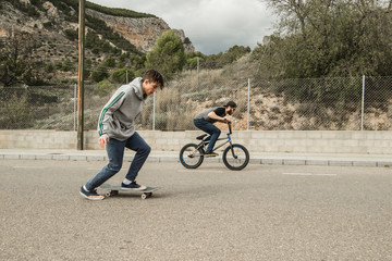 Extreme urban sports concept .Young people with bmx bicycles and skateboards on the street © Rafa