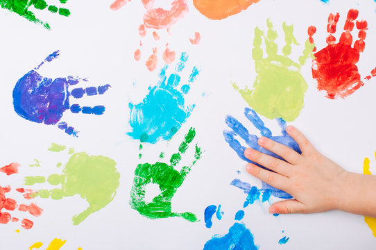 Kids hand making colored handprints on white background