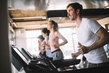 Fototapeta na wymiar People running on treadmill in gym doing cardio workout