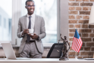 Office desk and objects with african american businessman on background