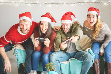 Group of happy friends having fun with video games console on christmas time