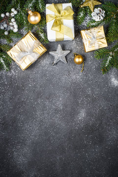 Christmas background with gold and silver decorations on black.