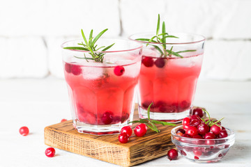 Cocktail with cranberry, vodka, rosemary and ice.