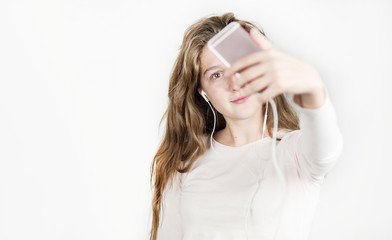 beautiful girl in headphones with a phone in her hands listens to music