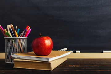 Teacher's desk with writing materials, a book and an apple, a blank for text or a background for a...