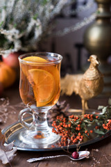 Hot steaming tea in a large glass mug on a vintage background