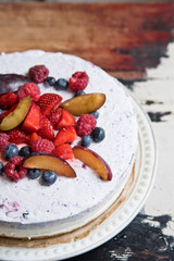 Yoghurt cake with berries on a vintage plate on the background of an old table