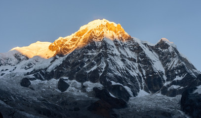 Panele Szklane  Zbliżenie na szczyt południowych gór Annapurny na tle błękitnego nieba podczas wschodu słońca (złota godzina) w Himalajach