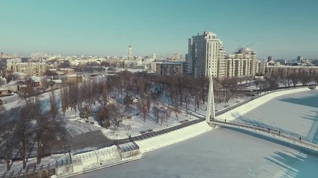Kharkiv, Ukraine - Dec 13, 2016: Aerial of Strelka park covered with snow, bridge over frozen river. Winter cityscape