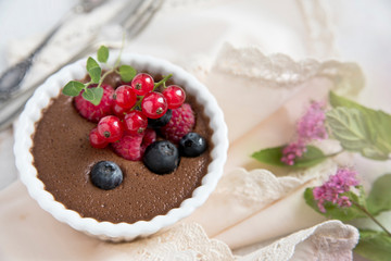 Chocolate mousse with berries on a light napkin and old spoon and fork. Copy space