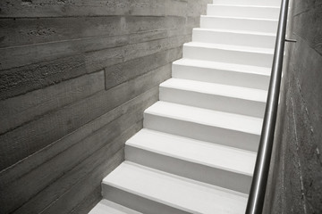 Modern reinforced concrete staircase with stainless handrail in interior of contemporary house, New...