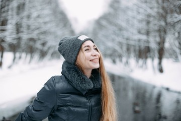 girl blonde in a snowy forest in winter clothes.