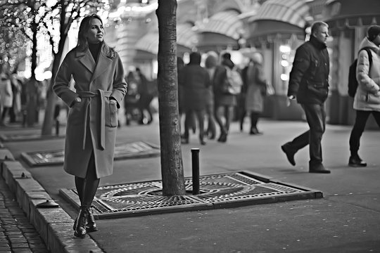 winter night in the city lights / adult girl in a coat walk in the city, fashionable stylish image of a beautiful model