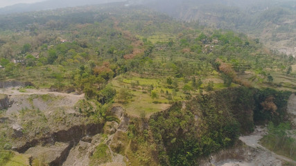 Fototapeta na wymiar mountain landscape slopes mountains covered with green tropical forest. Jawa, Indonesia. aerial view mountain forest with large trees and green grass.