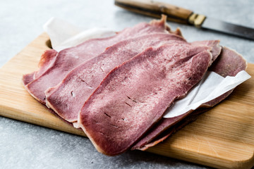 Sliced Beef Tongue Slices on Wooden Board.