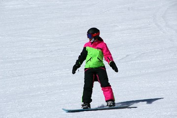 Fototapeta na wymiar girl in a colorful suit is on a snowboard rides with mountains