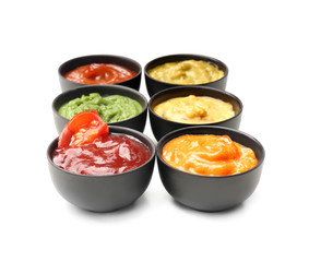 Different tasty sauces in bowls on white background