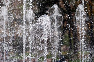 Many water streams, water splashes and drops in the fountain. Abstract background of water trickles and drops.