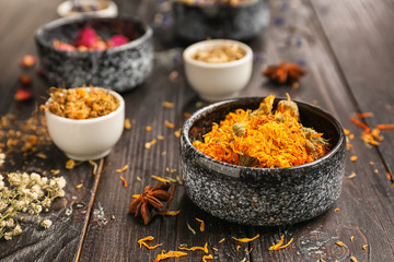 Bowls with dried flowers on dark wooden table