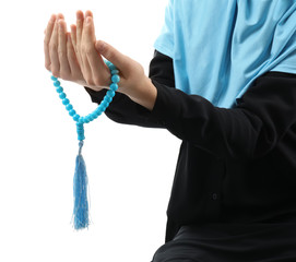 Muslim woman with beads praying on white background