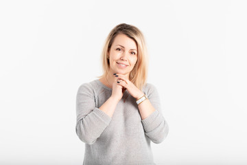 Fototapeta premium Portrait of attractive and smiling middle aged woman on grey background