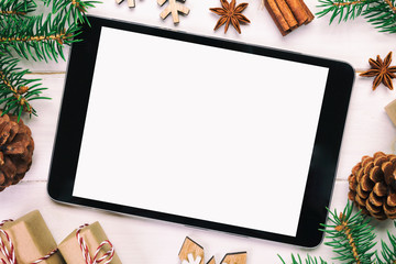 Digital tablet mock up with rustic Christmas wooden background decorations for app presentation. top view vintage, toned with copy space