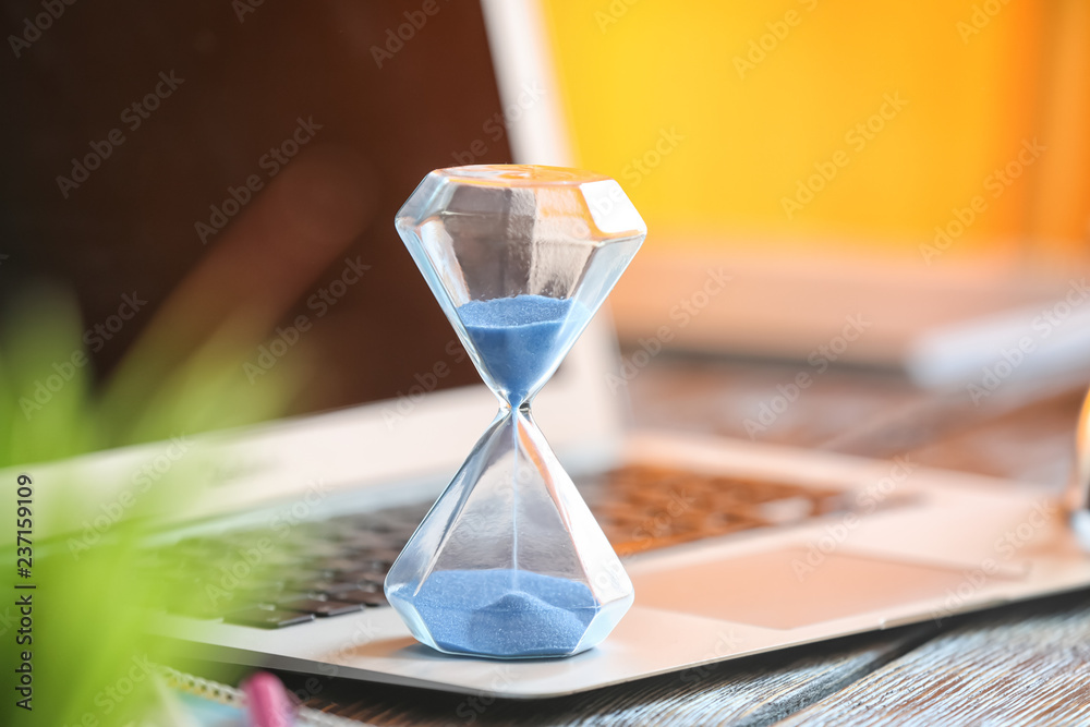 Wall mural hourglass on laptop keyboard. time management concept