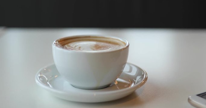 Cup of latte on table, little earthquake