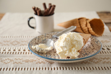 Waffle cone with delicious ice cream on plate