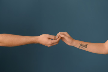 Man and woman holding hands on color background. Concept of support and help