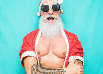 Tattoo fit Santa Clause wearing funny fest sunglasses - obrazy, fototapety, plakaty
