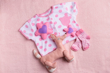 Baby clothes and toys on color towel, top view