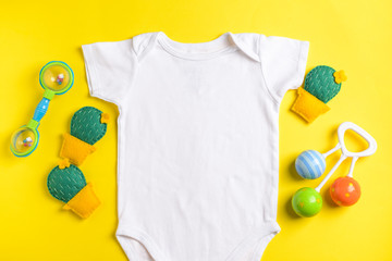 Baby clothes and toys on color background, top view