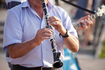 man playing clarinet on street