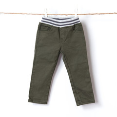 Baby boy pants hanging on the clothesline against white background