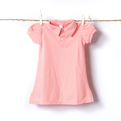 Girl t-shirt hanging on the clothesline against white background