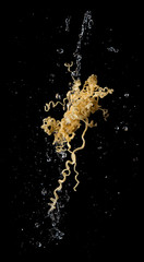 Instant noodles with soup splash or explosion flying in the air over dark background