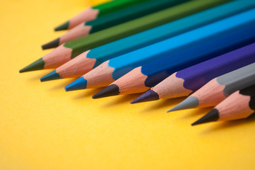Fototapeta premium closeup of colouring pencils on yellow background