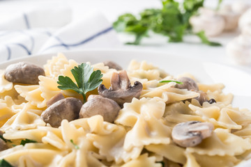 Close up pasta with mushroom and parsley on white wooden table.